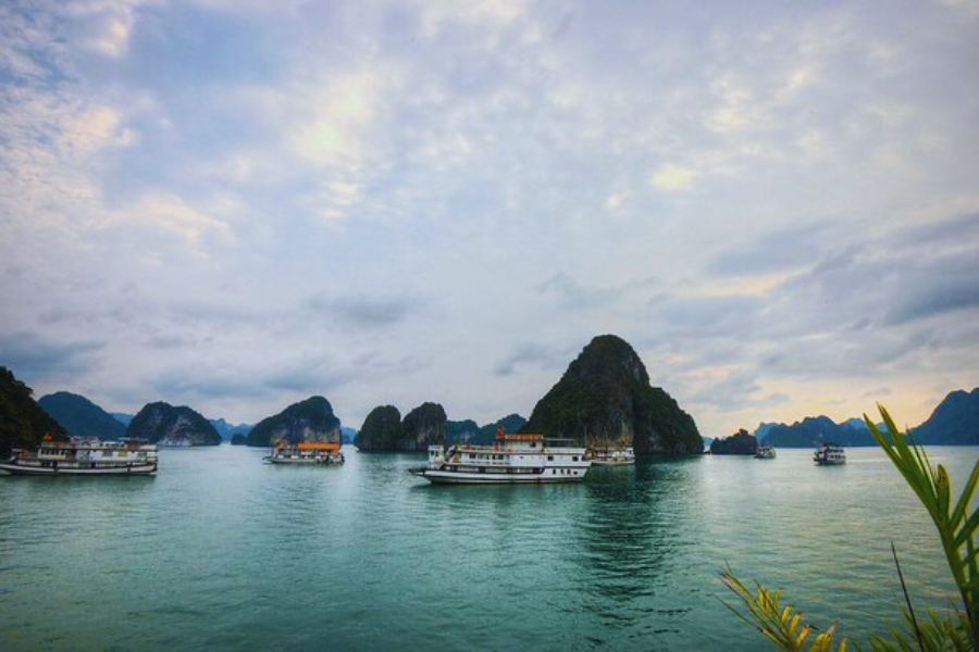 Anchored Halong Bay Budget Cruises under cloudy sky with Auasia Travel